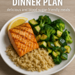 A white plate filled with a balanced diabetic-friendly meal consisting of grilled salmon, roasted zucchini and broccoli, and a serving of quinoa. A lemon wedge rests beside the salmon. The plate is placed on a light wooden surface. Overlaid text reads: "7-Day Diabetic Dinner Plan – delicious and blood sugar–friendly meals.